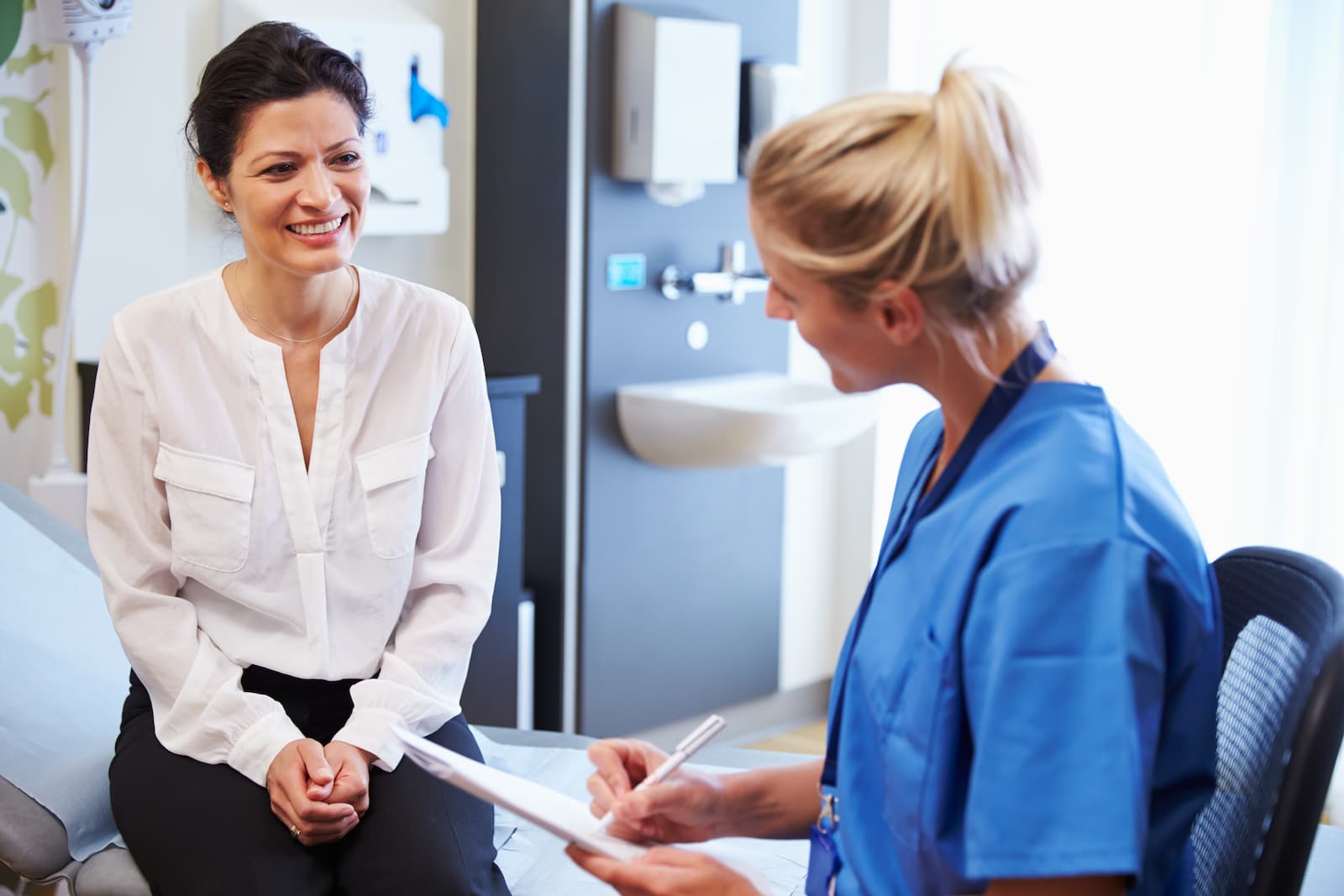 A picture of a doctor meeting with a smiling patient.